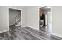 Open-concept living room with hardwood floors and views into the kitchen and hall at 1707 Stroll Cir, Fuquay Varina, NC 27526