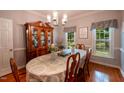 Traditional dining room with hardwood floors, crown molding, chandelier, and a large china cabinet at 2006 Chedington Dr, Apex, NC 27502