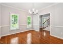 Elegant dining room featuring hardwood floors, natural light from the windows, and a modern chandelier at 2006 Chedington Dr, Apex, NC 27502