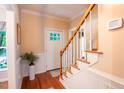 Bright foyer featuring hardwood floors, paneled wainscoting, white staircase, and a decorative glass paneled front door at 2006 Chedington Dr, Apex, NC 27502