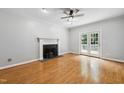 Cozy living room with a fireplace, hardwood floors, and french doors leading to the outside at 2006 Chedington Dr, Apex, NC 27502