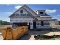 New home under construction featuring a garage and a bright blue sky background at 36 Mossman Ct, Zebulon, NC 27597