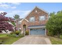 Charming brick home featuring a two-car garage, stone accents, and lush landscaping at 3614 Kilgo Dr, Durham, NC 27705