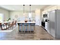 Beautiful, eat-in kitchen with gray island and white cabinets is complete with stainless steel appliances at 37 Mossman Ct, Zebulon, NC 27597