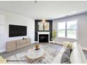 Inviting living room featuring modern decor, a sleek entertainment center, and a cozy fireplace at 37 Mossman Ct, Zebulon, NC 27597