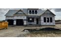 New construction home featuring a covered entry and garage, awaiting finishing touches in a developing community at 414 Springtooth Dr, Zebulon, NC 27597
