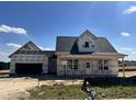 New home under construction featuring a modern design and an attached two car garage on a sunny day at 432 Springtooth Dr, Zebulon, NC 27597