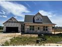 New home under construction featuring a modern design, two-car garage, and covered front porch at 432 Springtooth Dr, Zebulon, NC 27597