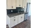 Stylish kitchen with granite countertops, stainless steel sink, and white cabinets with black hardware at 432 Springtooth Dr, Zebulon, NC 27597