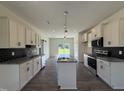 Modern kitchen features stainless appliances, granite countertops, and white cabinets with stylish dark hardware at 432 Springtooth Dr, Zebulon, NC 27597