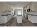 Bright, new kitchen with white cabinets, granite countertops, stainless appliances, and a center island at 432 Springtooth Dr, Zebulon, NC 27597