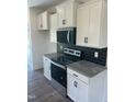 Modern kitchen featuring stainless steel appliances, sleek black backsplash, and bright white cabinetry at 432 Springtooth Dr, Zebulon, NC 27597