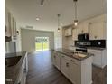 Contemporary kitchen with island, sleek appliances, and seamless access to an adjacent dining area at 432 Springtooth Dr, Zebulon, NC 27597