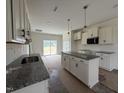 Open kitchen with granite counters, white cabinets, stainless appliances, and an island with extra storage at 432 Springtooth Dr, Zebulon, NC 27597