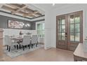 Elegant dining room with a coffered ceiling, stylish chandelier, and a gray accent wall with wainscoting at 4508 Chandler Creek Pl, Apex, NC 27539