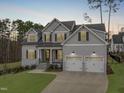 Charming two-story home featuring a manicured lawn, gray siding, dormer windows and a two car garage at 4508 Chandler Creek Pl, Apex, NC 27539