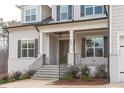 Charming home featuring an inviting front porch, well-kept landscaping and an elegant, glass-paneled front door at 4508 Chandler Creek Pl, Apex, NC 27539