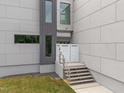 Stylish home entrance featuring a modern staircase and sophisticated gray and white facade at 5217 Tanglewild Dr, Raleigh, NC 27613