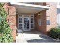 Charming brick condo entrance with a cozy bench and well-lit doorway at 528 Weather Ridge Ln, Cary, NC 27513