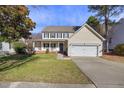 Inviting two-story home with a cozy front porch, lush green lawn, and attached garage at 5401 Green Feather Ln, Raleigh, NC 27604