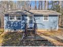 Charming single-story home with blue siding, surrounded by a beautiful wooded area with a welcoming front porch at 5500 Bobbitt Rd, Apex, NC 27539
