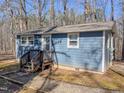Charming single-story home with blue siding, surrounded by a beautiful wooded area and inviting front entrance at 5500 Bobbitt Rd, Apex, NC 27539