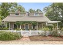 Charming home with a white picket fence and a cozy covered front porch with verdant plants at 613 S Fuquay Ave, Fuquay Varina, NC 27526