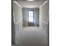Bright entryway featuring classic wainscoting and a charming wooden front door at 108 Pointe Park Cir, Holly Springs, NC 27540