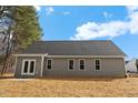 Rear exterior featuring gray siding, white trim, double doors, and a concrete patio at 111 Averly Ct, Stem, NC 27581