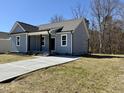 Beautiful single-story home with a long concrete driveway, a covered porch, and manicured front yard at 119 Daniel St, Oxford, NC 27565