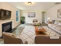 Bright living room with a cozy fireplace, neutral furniture, and large windows at 135 N Ridge View Way, Franklinton, NC 27525