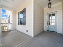 Inviting covered front porch features decorative pillars, light fixture, and light blue front door at 20 Wildflower Ln, Franklinton, NC 27525