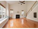 Spacious living room with hardwood floors, a fireplace, large windows and a ceiling fan at 2017 Ollivander Dr, Cary, NC 27519