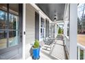 Cozy covered front porch with seating area, featuring a gray ceiling and a view of the front yard at 260 Culbreth Rd, Chapel Hill, NC 27516