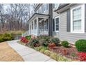 Close up of front porch with manicured landscaping, a stone border, and a walkway to the home at 260 Culbreth Rd, Chapel Hill, NC 27516