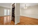 Open-concept living room with hardwood flooring, built-in shelving, and ample natural light at 3213 Coachmans Way, Durham, NC 27705