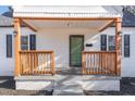 Inviting front porch with wooden railings, black shutters, and a gray tiled porch and brick foundation at 328 Cleveland St, Rocky Mount, NC 27803