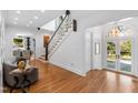 Bright foyer with hardwood floors, staircase, and view to front doors and adjoining dining room at 330 Tenney Circle, Chapel Hill, NC 27514