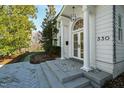 Elegant front entrance featuring a column-framed doorway, stone steps, and professional landscaping at 330 Tenney Circle, Chapel Hill, NC 27514