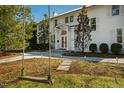 Charming two-story white home featuring mature trees, a front yard swing, and a beautifully landscaped walkway at 330 Tenney Circle, Chapel Hill, NC 27514