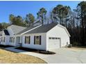 View of the home with attached garage, white siding, black shutters, and concrete driveway at 343 Magnolia Run Way, Benson, NC 27504