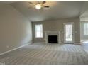 Spacious living room with a fireplace, neutral carpet, ceiling fan, and a door to the outside at 343 Magnolia Run Way, Benson, NC 27504