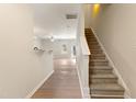 Bright entryway featuring wood floors, stairs with carpeted steps and white risers, open to a spacious living area at 3931 Volkswalk Pl, Raleigh, NC 27610