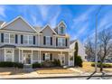 Charming townhome featuring a covered front porch, neutral siding, and black shutters, set against a bright blue sky at 3931 Volkswalk Pl, Raleigh, NC 27610