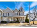 Charming townhome featuring a covered front porch, neutral siding, and black shutters, set against a bright blue sky at 3931 Volkswalk Pl, Raleigh, NC 27610