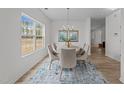 Elegant dining room with natural light, chandelier, and a view of the backyard on luxury vinyl flooring at 4207 Hampstead Village Dr, Durham, NC 27703