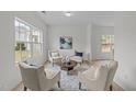 Bright living room with large windows, comfortable seating, and modern decor on luxury vinyl flooring at 4207 Hampstead Village Dr, Durham, NC 27703