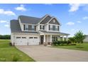 Inviting two-story home with a three-car garage, covered porch, and meticulously maintained front yard at 6804 Arlington Oaks Trl, Raleigh, NC 27603