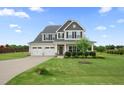 Inviting two-story home boasts a two-car garage, covered entry, and expansive front yard with mature landscaping at 6804 Arlington Oaks Trl, Raleigh, NC 27603