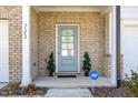 Inviting front porch with brickwork, decorative plants, and an ADT security sign, ensuring peace of mind at 723 Toulouse Ct, Cary, NC 27519